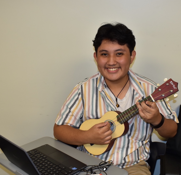 Student holding a ukulele